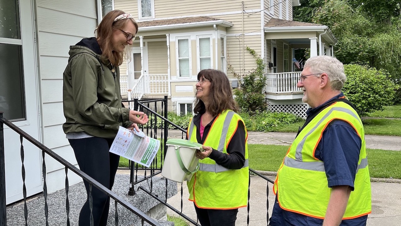 Emily Piper of Bay City, left, discusses details of Iris Waste Diversion Specialists’ new food scrap collection pilot program for residents in Bay City and Saginaw with Iris CEO Sarah Archer and her husband, Darrell Reed